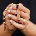 manos rezando con el rosario